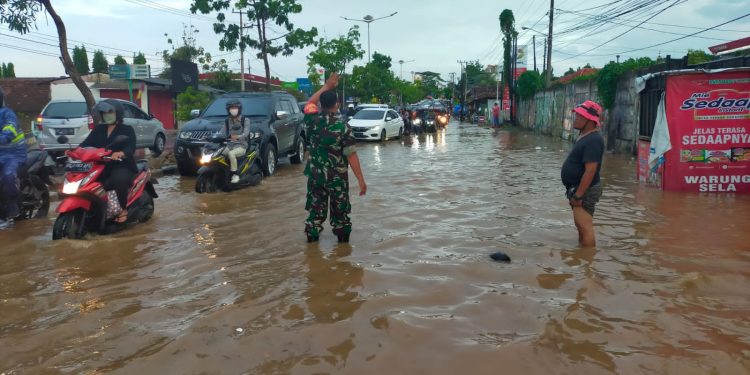 Cegah Kemacetan Karena Banjir, Babinsa bersama Camat, Lurah, Bhabinkamtibmas dan Warga Bantu Kelancaran Arus Lalu Lintas