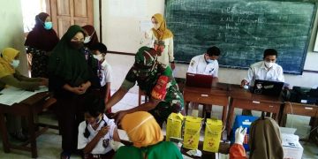 Kepedulian Babinsa Kepada Siswa SD Saat Menerima Vaksinasi