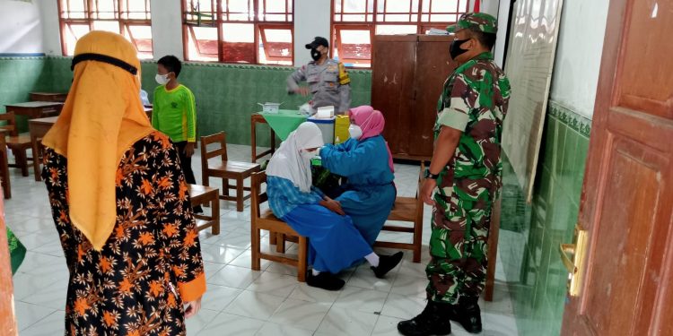Bersama Bhabinkamtibmas, Serka Agus Heri Dampingi Anak-Anak Usia 6-11 Tahun Terima Vaksin
