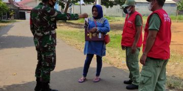 Wujud Kepedulian, Babinsa Serma Ari Bersama Linmas Bagikan Masker Gratis
