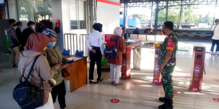 Sinergi..!! Sertu Murdianto Bersama Petugas Stasiun dan Security Berikan Himbauan Prokes Kepada Penumpang di Stasiun Purwosari