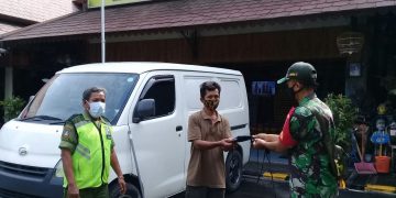 Babinsa Keprabon Berikan Himbauan Prokes dan Bagikan Masker Gratis di Pasar Triwindu