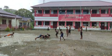 Personel Satgas TMMD Bermain Sepak Bola Bersama Anak-anak Meski Diguyur Hujan