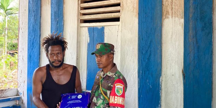 Peduli Kesehatan Warga Binaan, Babinsa Koramil 1710-06/Agimuga Dampingi Nakes Bagikan Kelambu Berinsektisida