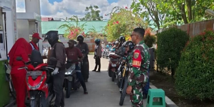 Bantu Kelancaran Operasional Saat Kelangkaan BMM, Babinsa Koramil 1710-02/Timika Turun Tangan Tertibkan Antrian di SPBU