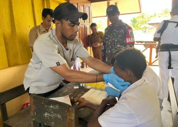 Peduli Kondisi Kesehatan Generasi Penerus Bangsa, Babinsa Koramil 1710-06/Agimuga Dampingi Nakes Pemeriksaan Kesehatan Kepada Pelajar