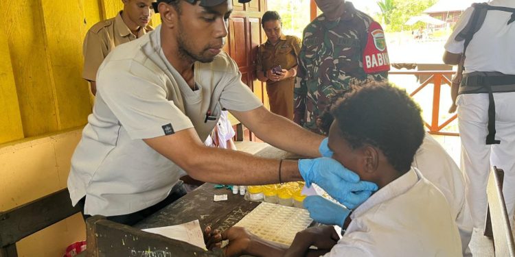 Peduli Kondisi Kesehatan Generasi Penerus Bangsa, Babinsa Koramil 1710-06/Agimuga Dampingi Nakes Pemeriksaan Kesehatan Kepada Pelajar